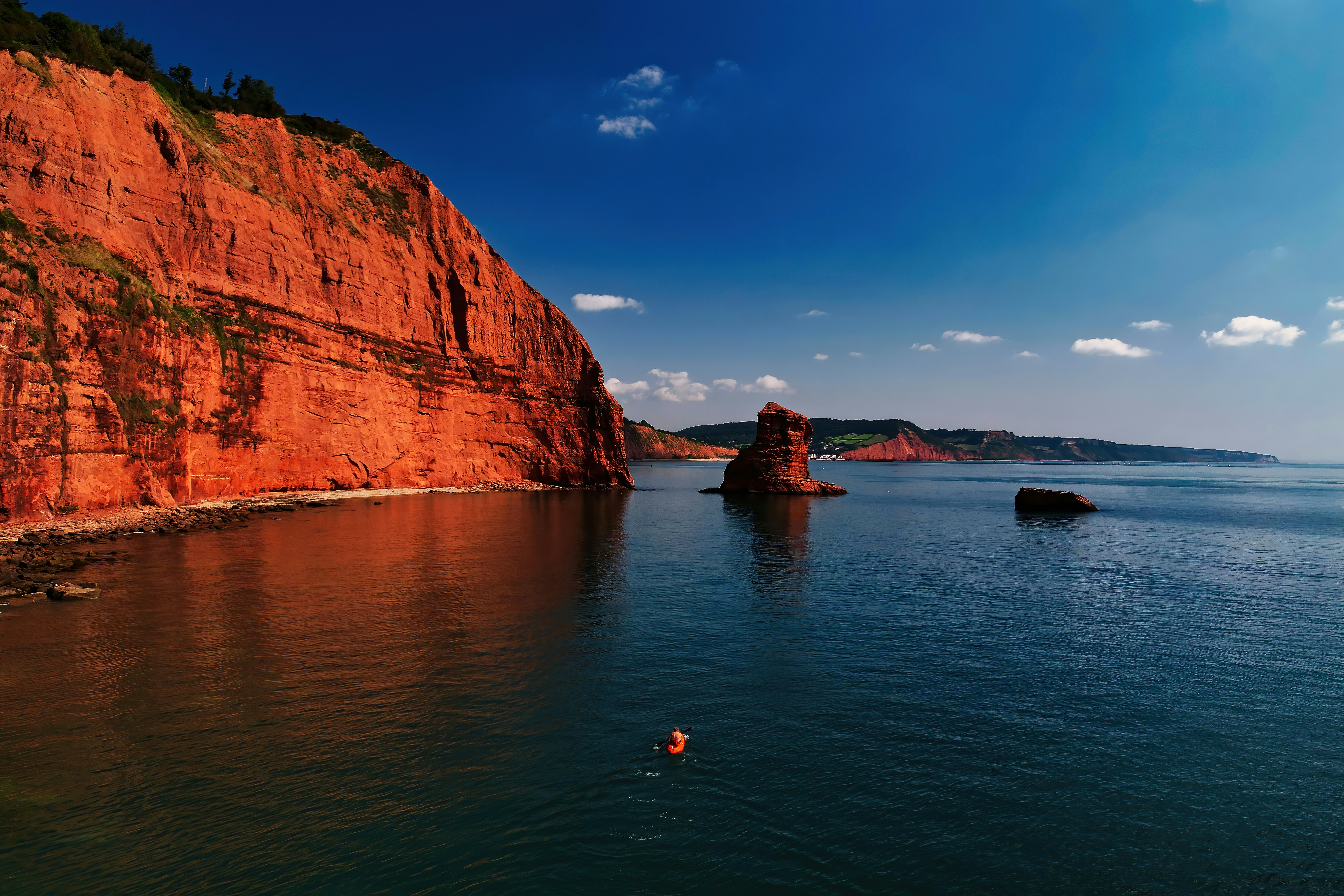 brown rock formation beside body of water during daytime